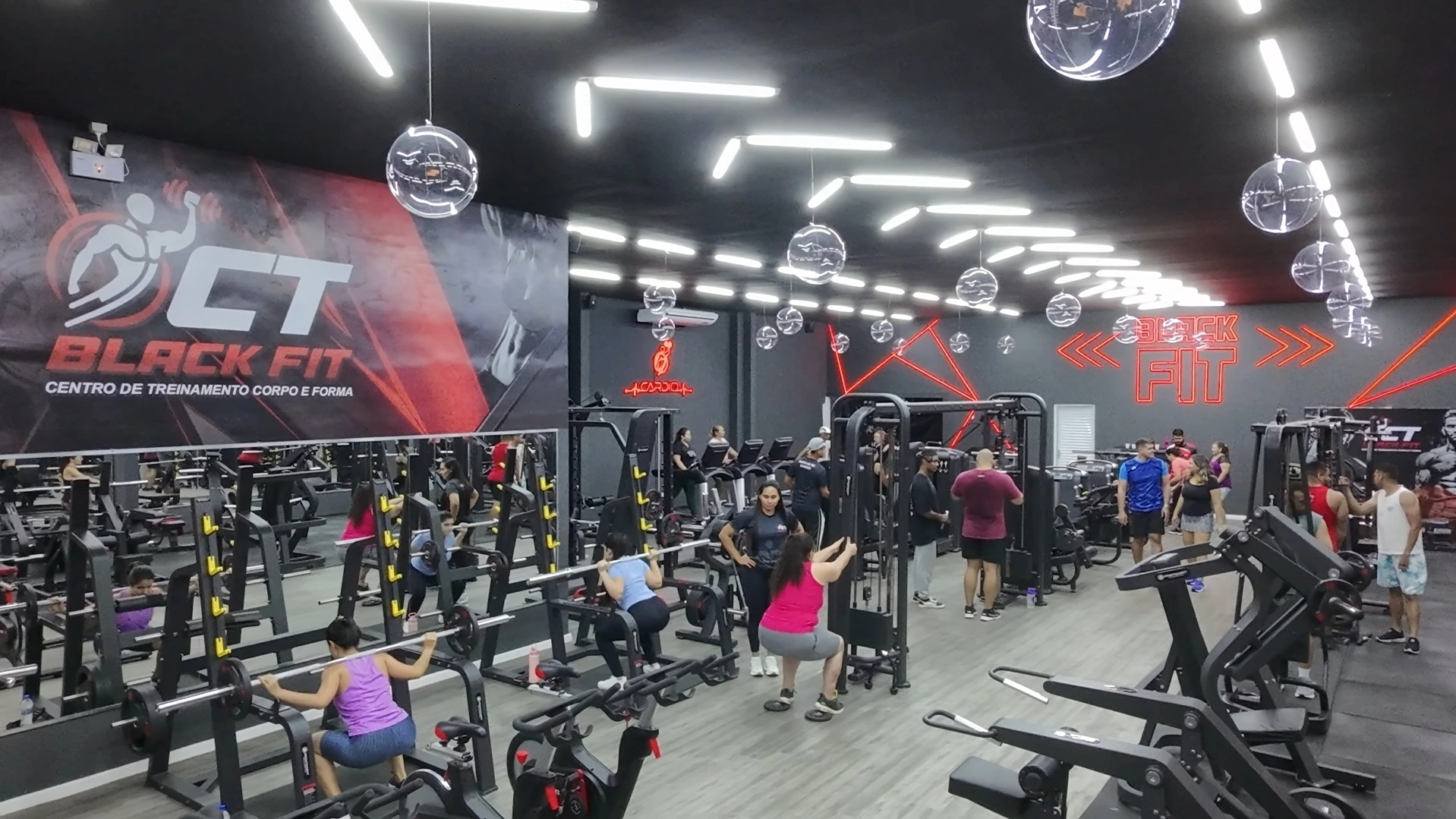 Visão interna da academia com ambiente amplo e limpo, inspirando motivação.